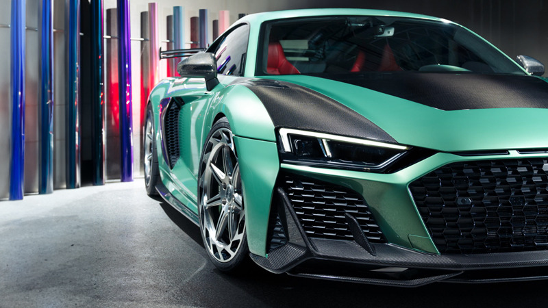 Side view of a green and black PPF-wrapped car standing in a studio